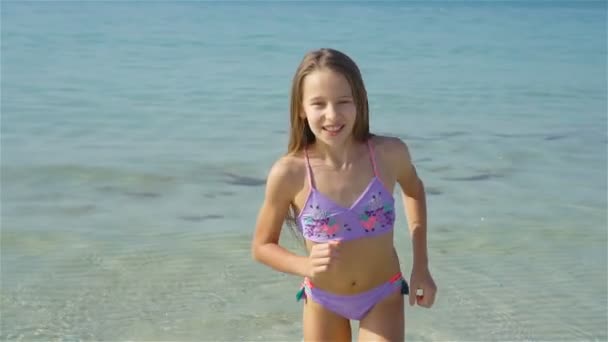 Schattig klein meisje aan het strand tijdens de zomervakantie — Stockvideo