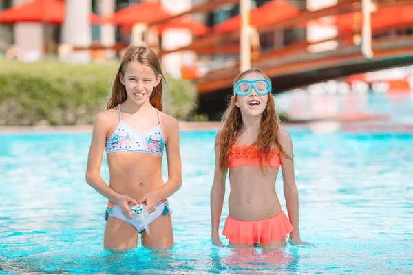 Schattige kleine meisjes spelen in het buitenzwembad op vakantie — Stockfoto