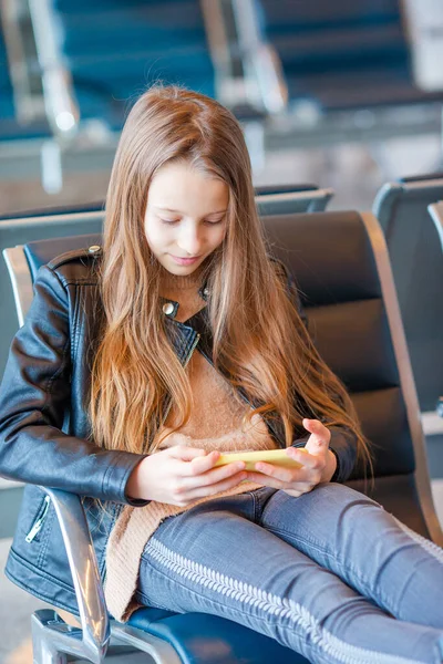 Entzückendes kleines Mädchen am Flughafen in großen internationalen Flughafen in der Nähe des Fensters — Stockfoto