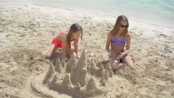 Två små glada flickor har mycket roligt på tropiska stranden leker tillsammans — Stockvideo