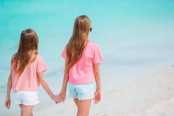 Kleine fröhliche lustige Mädchen haben viel Spaß am tropischen Strand beim gemeinsamen Spielen. — Stockfoto