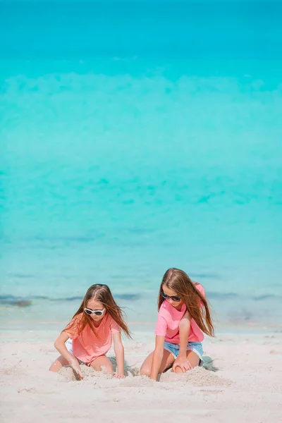 Lite glada roliga tjejer har mycket roligt på tropiska stranden leker tillsammans. — Stockfoto