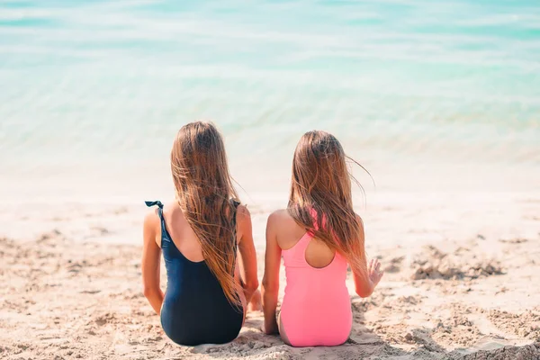 Kleine fröhliche lustige Mädchen haben viel Spaß am tropischen Strand beim gemeinsamen Spielen. — Stockfoto