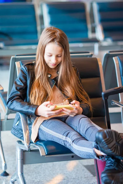 Entzückendes kleines Mädchen am Flughafen in großen internationalen Flughafen in der Nähe des Fensters — Stockfoto