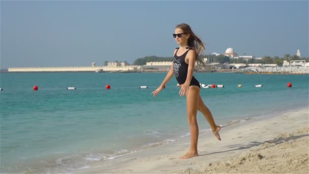 Yaz tatili boyunca sahilde sevimli, aktif küçük bir kız. — Stok video