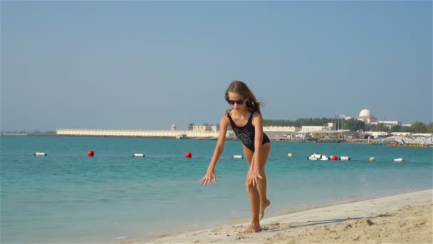 Underbar aktiv liten flicka på stranden under sommarlovet — Stockvideo