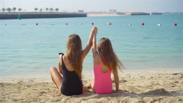 Két boldog kislány jól szórakozik a trópusi parton, együtt játszanak. — Stock videók