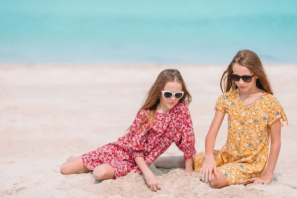 Zwei kleine glückliche Mädchen haben viel Spaß am tropischen Strand beim gemeinsamen Spielen — Stockfoto