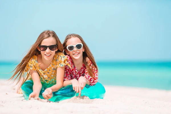 Duas meninas felizes se divertem muito na praia tropical jogando juntas — Fotografia de Stock