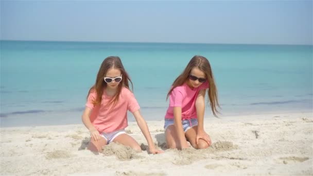 Duas meninas felizes se divertem muito na praia tropical jogando juntas — Vídeo de Stock