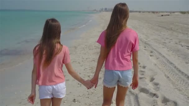 Маленькі щасливі смішні дівчата отримують багато задоволення на тропічному пляжі, граючи разом . — стокове відео