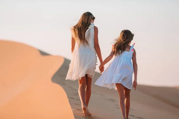 Girls among dunes in big desert in Emirates — Stock Photo, Image