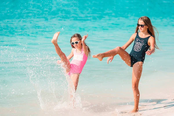 Pequenas meninas engraçadas felizes se divertir muito na praia tropical jogando juntos. — Fotografia de Stock