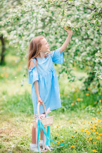 Adorable niña en el jardín de manzanas en flor en hermoso día de primavera —  Fotos de Stock