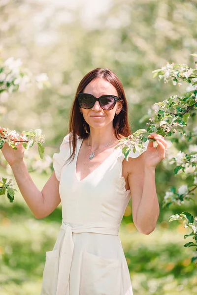 Schöne Frau genießt Duft im Frühlingskirschgarten — Stockfoto