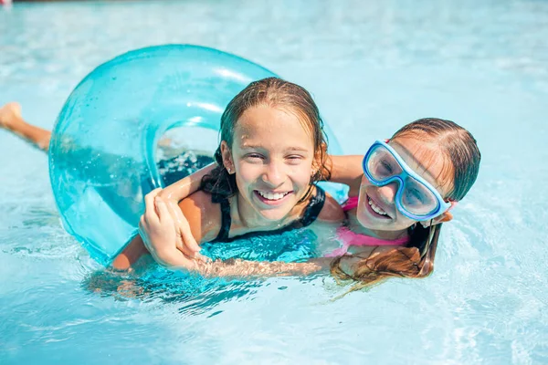 Adorable little sisters play in outdoor swimming pool — Stock Photo, Image