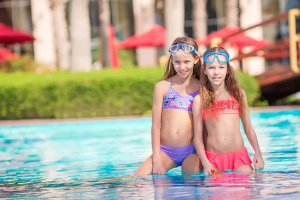 Adorables niñas jugando en la piscina al aire libre de vacaciones —  Fotos de Stock