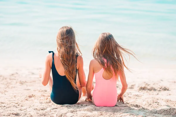 Pequeñas chicas divertidas felices tienen un montón de diversión en la playa tropical jugando juntos. —  Fotos de Stock