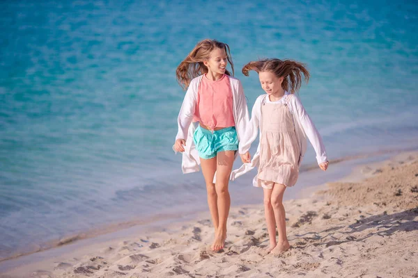 Lite glada roliga tjejer har mycket roligt på tropiska stranden leker tillsammans. — Stockfoto