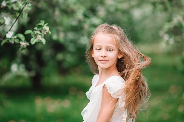 Çiçekli elma bahçesinde küçük sevimli bir kız güzel bir bahar günü — Stok fotoğraf