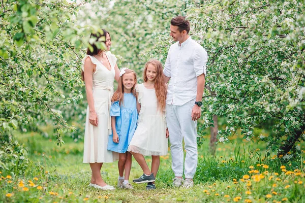 Adorable family in blooming cherry garden on beautiful spring day — Stock Photo, Image
