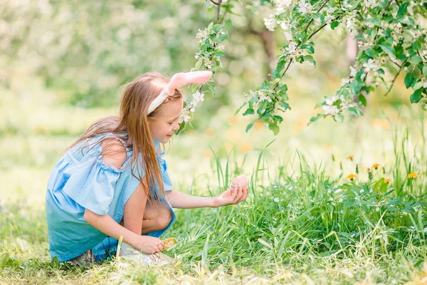 Liebenswertes kleines Mädchen im blühenden Apfelgarten an einem schönen Frühlingstag — Stockfoto