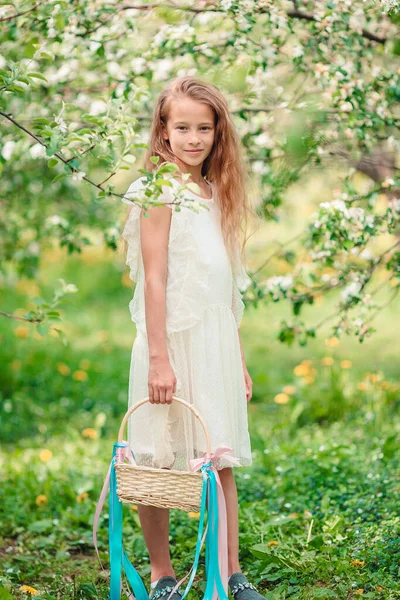 Adorable niña en el jardín de manzanas en flor en hermoso día de primavera —  Fotos de Stock