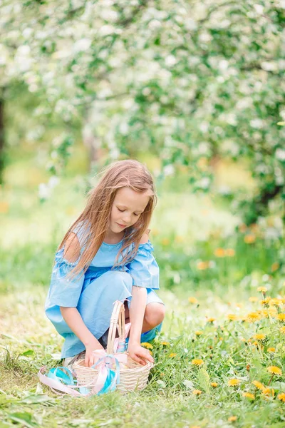 Liebenswertes kleines Mädchen im blühenden Apfelgarten an einem schönen Frühlingstag — Stockfoto