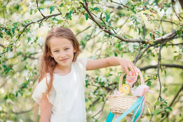 Liebenswertes kleines Mädchen im blühenden Apfelgarten an einem schönen Frühlingstag — Stockfoto