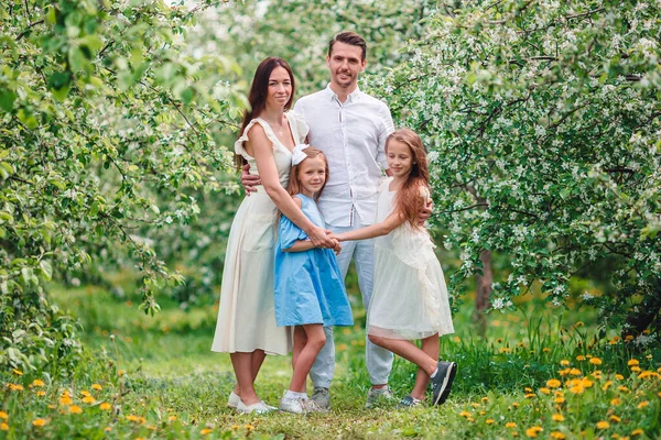 Adorable family in blooming cherry garden on beautiful spring day — Stock Photo, Image
