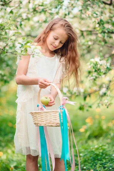 Söt liten flicka i blommande äppelträdgård på vacker vårdag — Stockfoto