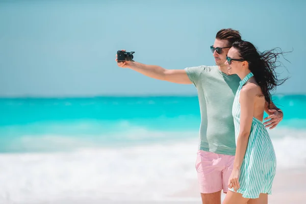 Счастливая пара фотографируется на белом пляже в праздник медового месяца — стоковое фото