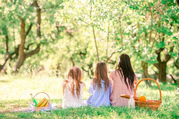 Šťastná matka a dcerušky odpočívají u jezera — Stock fotografie