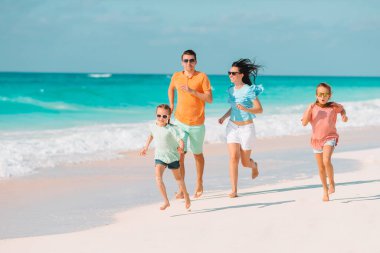 Yaz tatili boyunca sahilde mutlu bir aile.