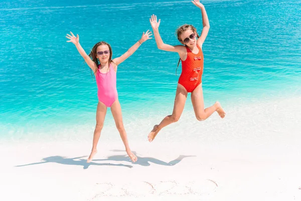 Pequenas meninas engraçadas felizes se divertir muito na praia tropical jogando juntos. — Fotografia de Stock