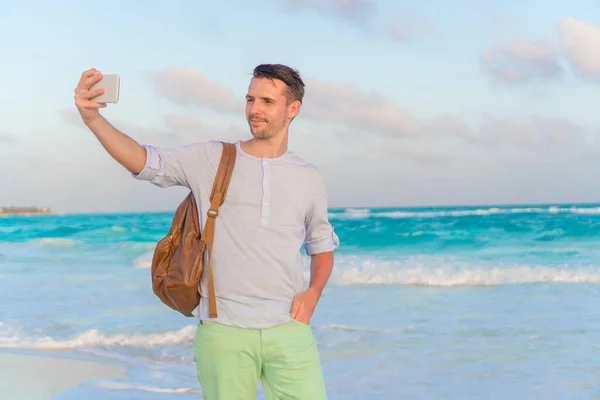 Giovane che prende selfie sullo sfondo della spiaggia il mare — Foto Stock