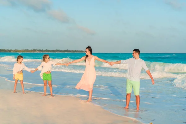 Familia joven con dos hijos en vacaciones en la playa — Foto de Stock