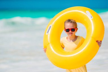 Sevimli küçük kız sahilde eğleniyor.