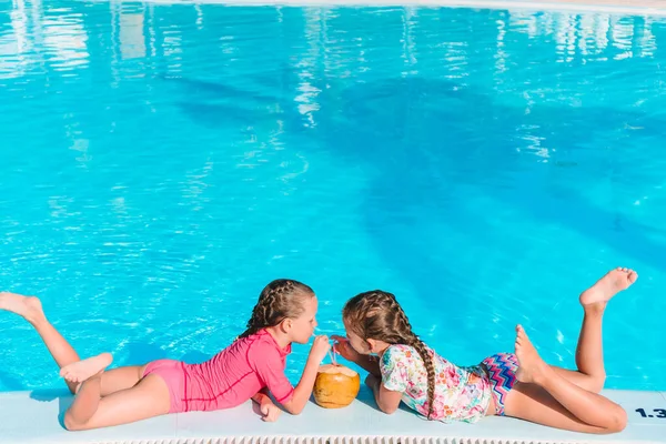 Adorables niñas jugando en la piscina al aire libre de vacaciones —  Fotos de Stock