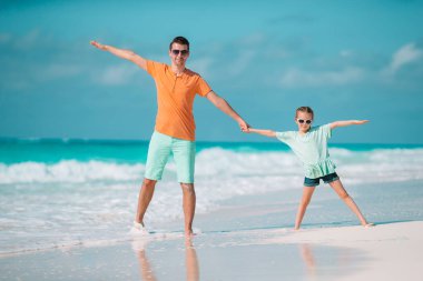 Mutlu baba ve sevimli küçük kızı tropikal plaj birlikte yürüme