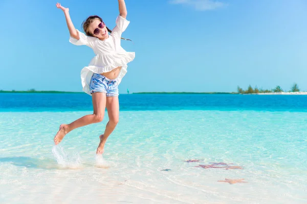 Bedårande glad liten flicka ha kul på strandsemester — Stockfoto