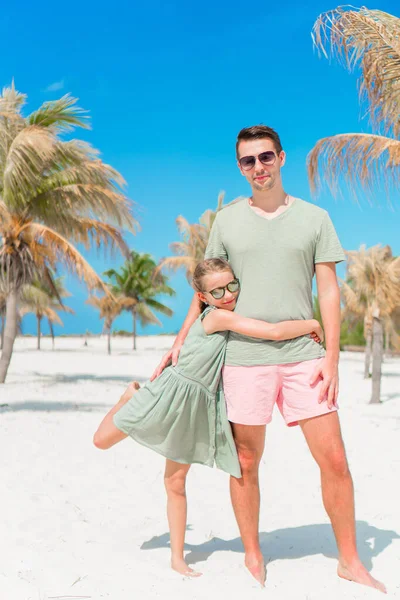 Vader en kleine meisjes hebben een heleboel plezier op witte zandstrand — Stockfoto