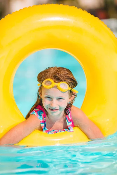 Adorable little girl swimming at outdoor swimming pool — Stock Photo, Image