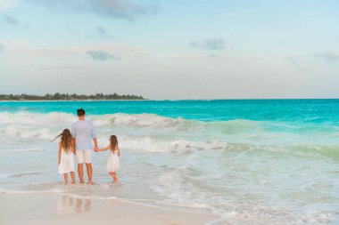 Tropik bir sahil tatilinde mutlu ve güzel bir aile.
