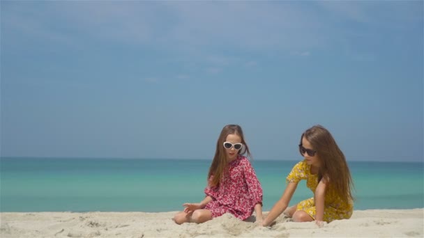 Duas meninas felizes se divertem muito na praia tropical jogando juntas — Vídeo de Stock