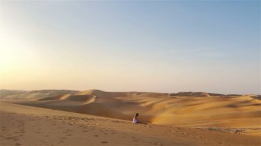 Birleşik Arap Emirlikleri 'ndeki Rub al-Khali çölündeki kum tepeleri arasında bir kız.