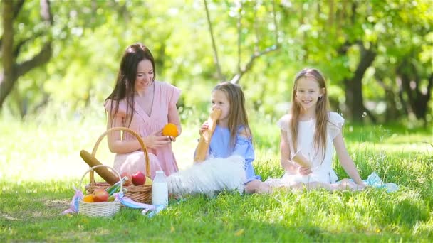 Feliz madre y niñas se relajan junto al lago — Vídeo de stock