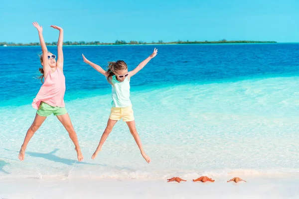 Adorable little girls have a lot of fun on the beach. — Stock Photo, Image