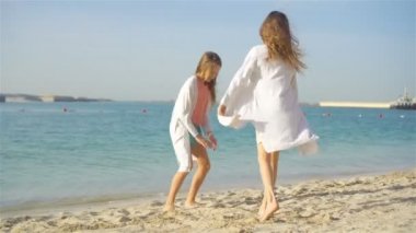 Çocuklar tropikal plajda birlikte oynarken eğleniyorlar.