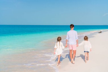 Tropik bir sahil tatilinde mutlu ve güzel bir aile.